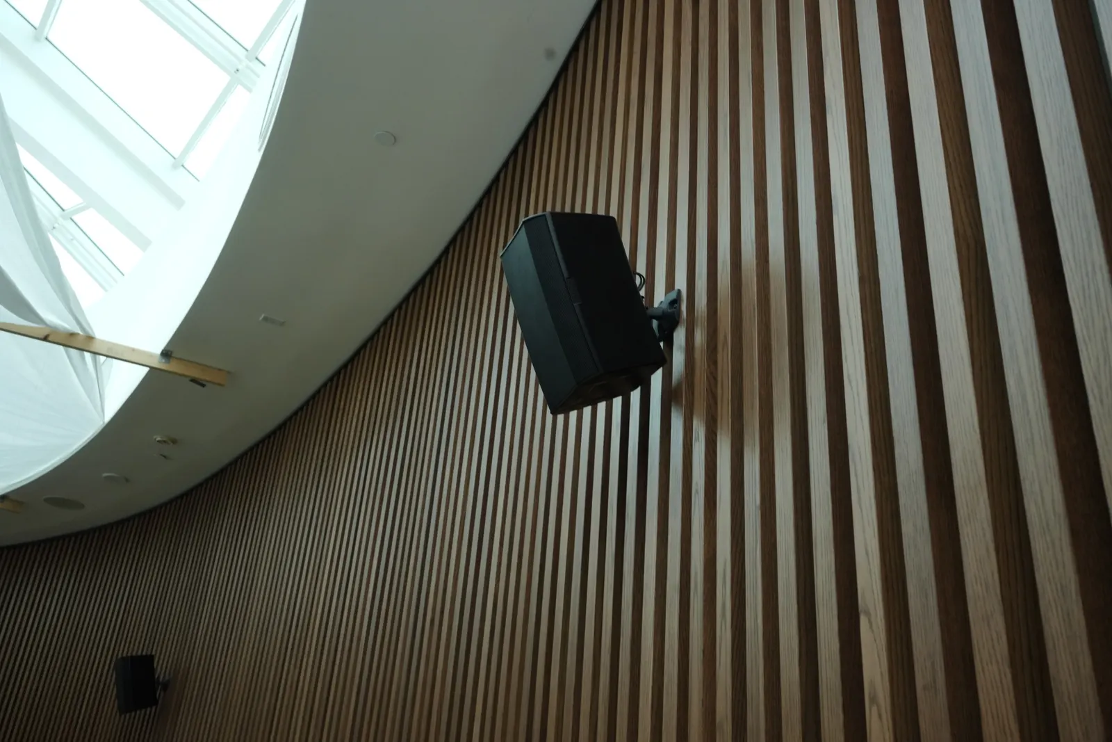 Surface-mounted loudspeaker on a wood slat wall